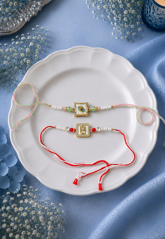Two traditional Indian Rakhi bracelets with gold-toned bangles and red/white threads, displayed on a white scalloped plate with decorative blue flowers and a blue candle in the background.